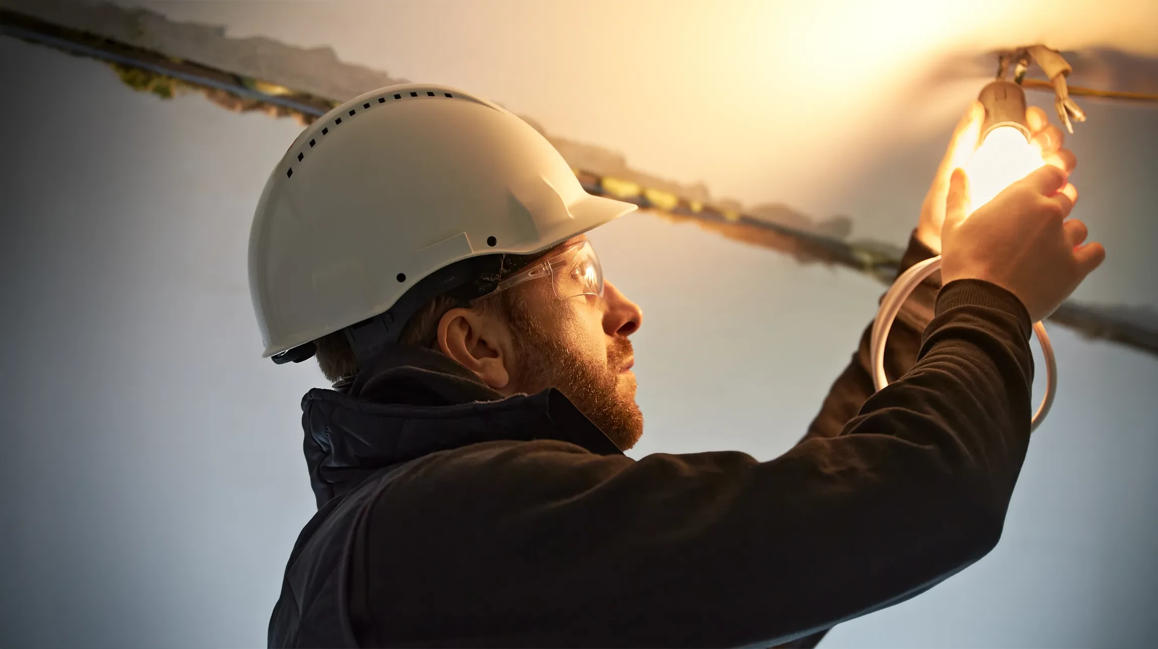 Un &eacute;lectricien teste un tableau &eacute;lectrique &agrave; l'aide d'un multim&egrave;tre num&eacute;rique