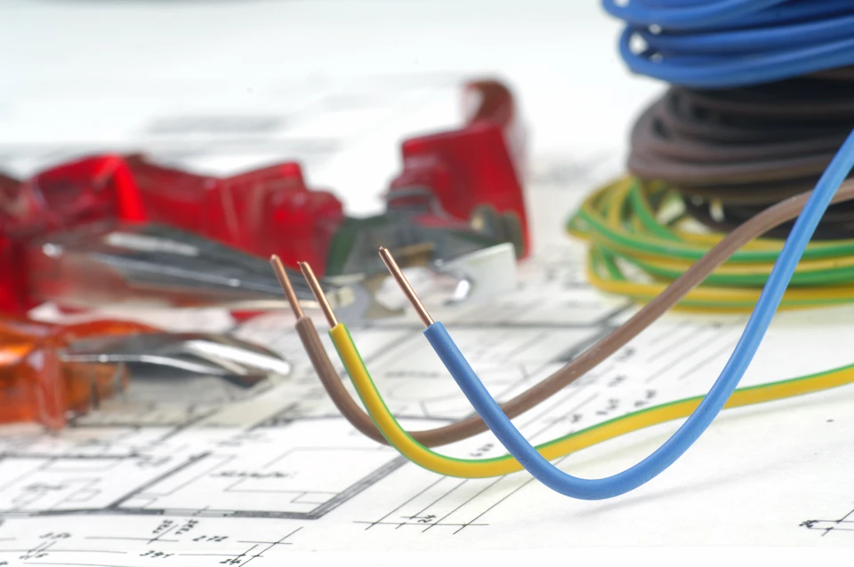 Deux professionnels du bâtiment examinent des plans architecturaux dans un bureau ensoleillé