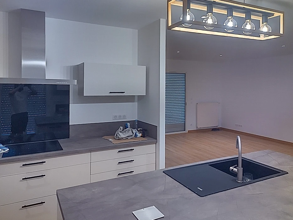 Chantier de rénovation énergétique avec installation d'équipements électriques sur mur en pierre apparente