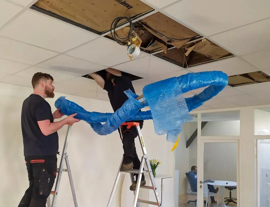 Salle de contrôle électrique industrielle avec rangées d'armoires électriques grises alignées dans un couloir